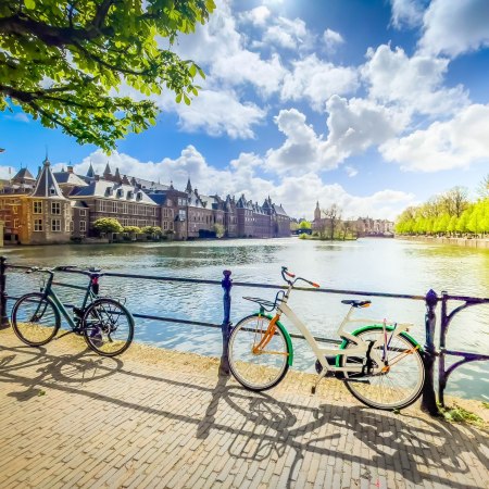 Bikes by a canal in The Hague with the Dutch Parliament in the background