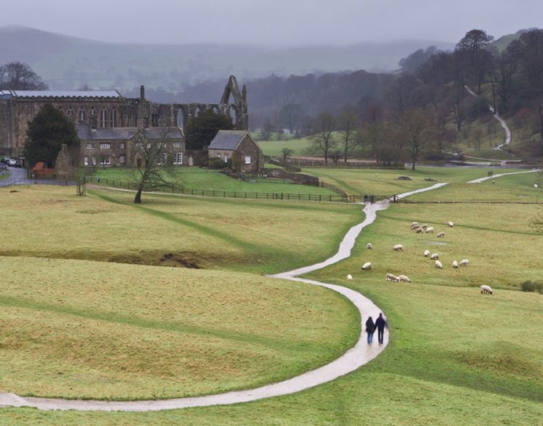 Two people walk the Dales Way in the distance on walking holiday with The Carter Company