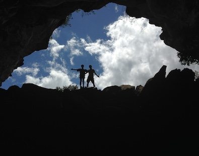 Walking holiday photo of two of the Carter Company team, taken from a cave and silhouetted against a blue sky