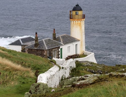 Photo of lighthouse from a cliff looking out to sea